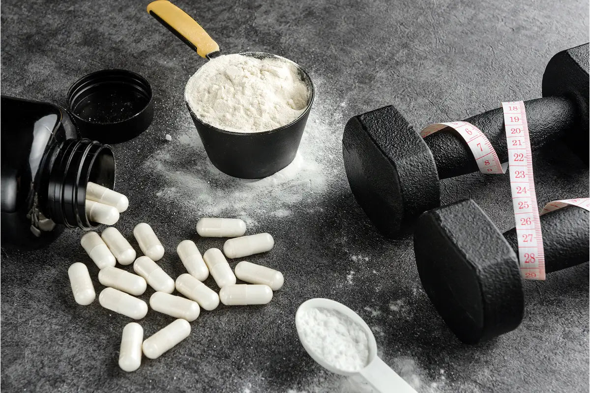 Supplement capsules and powder next to dumbbells